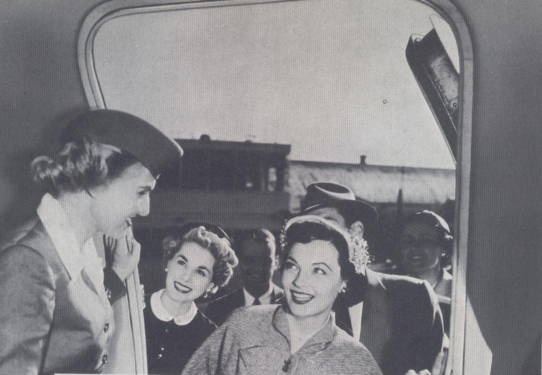 1950s A stewardess greets customers in the doorway of a Pan Am Clipper.